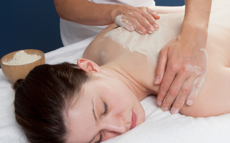 Ayurvedic massage in Amritsar showing Udvartana therapy with herbal powder massage treatment for weight management, circulation improvement, and body detoxification.
